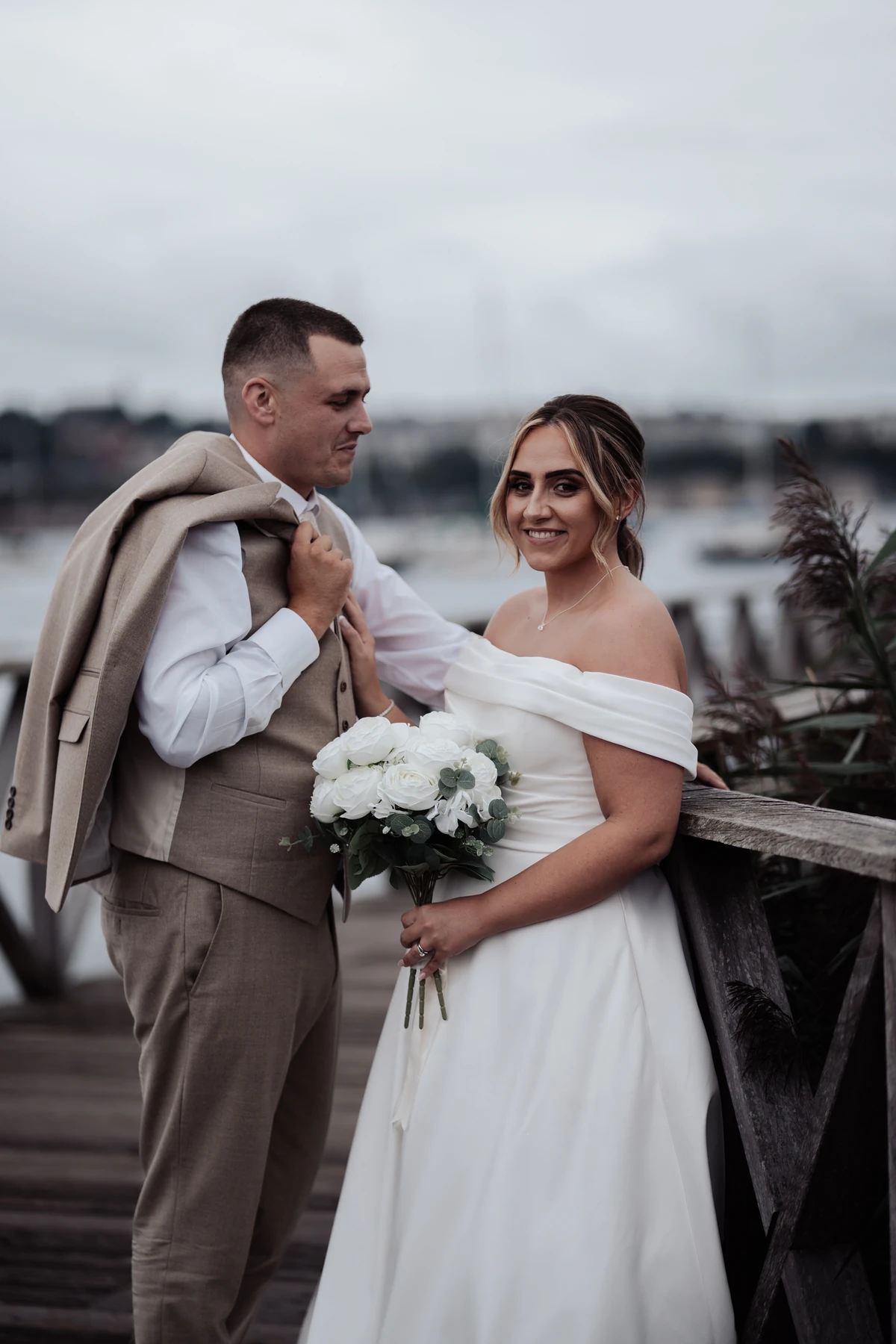 Bride and groom posing for a portrait on a wooden walkway in Cardiff Bay, South Wales.