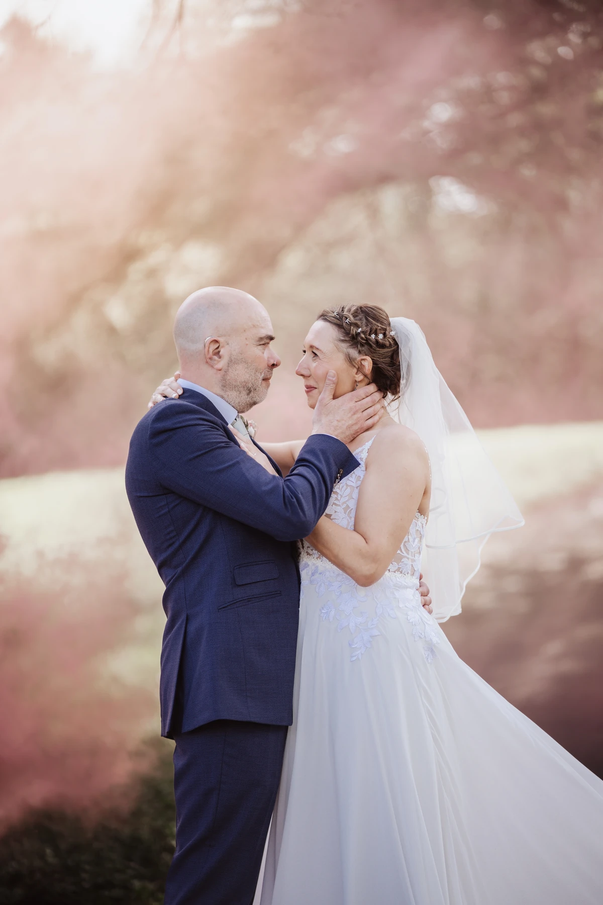 The bride and groom pose amid the serene gardens of Bedwellty House in Tredegar. Framed by mature trees and the stately backdrop of the historic building, their relaxed expressions and graceful attire reflect the romantic charm of this setting.
