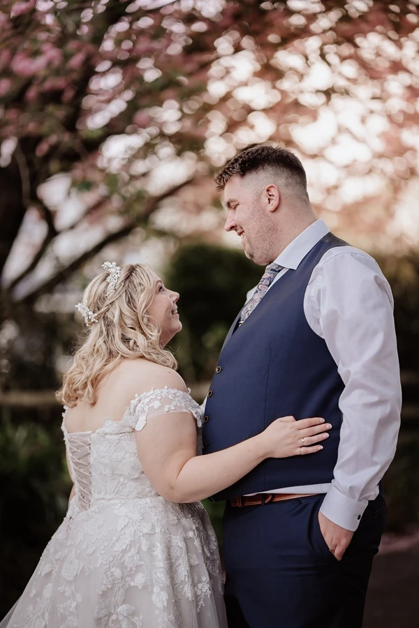 Wedding ceremony inside the Old Barn in South Wales, with spring flowers visible.