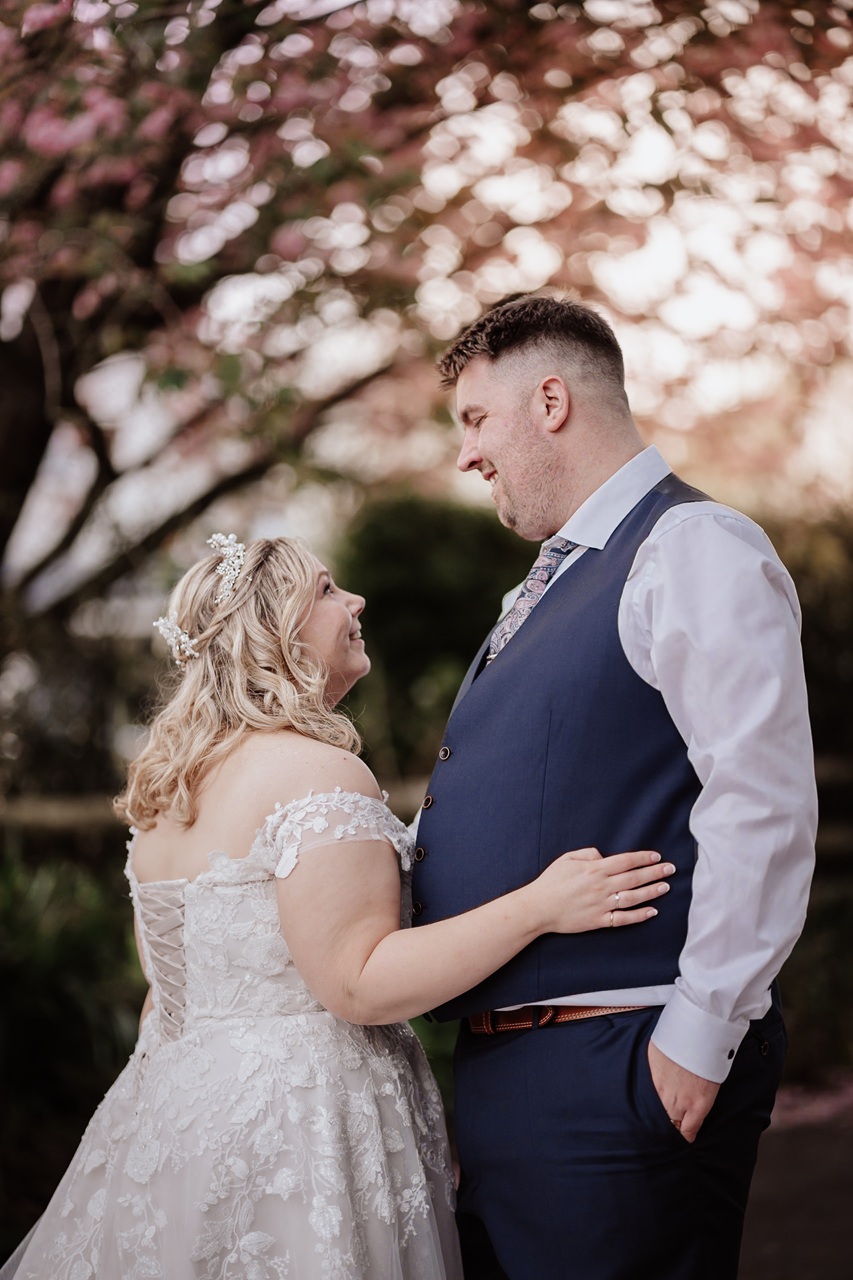 Wedding ceremony inside the Old Barn in South Wales, with spring flowers visible.