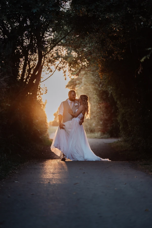 Bride and groom embracing on a lane at sunset in Bristol.
